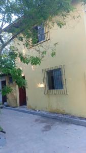 un edificio con dos ventanas de barrotes y un árbol en Casa de Praia Mosqueiro - São Francisco, en Belém