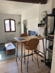 einen Holztisch mit zwei Stühlen in einem Zimmer in der Unterkunft Appartement cœur du centre-ville in Avignon