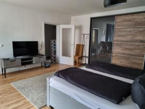 sypialnia z dużym łóżkiem i telewizorem z płaskim ekranem w obiekcie Frankfurt City Apartment w Frankfurcie nad Menem
