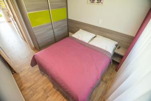 un piccolo letto con una coperta rosa in una stanza di Ostoja a Turawa