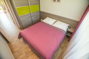 a small bed with a pink blanket in a room at Ostoja in Turawa