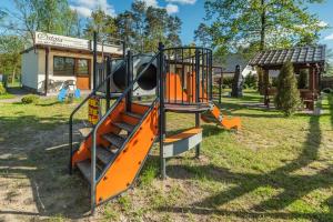 a playground with an orange slide in a park at Ostoja in Turawa