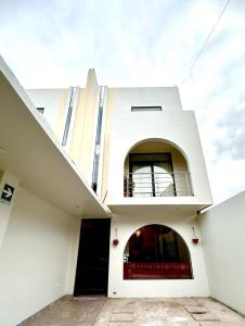 ein weißes Gebäude mit Balkon darüber in der Unterkunft LA CASA REAL in Puno