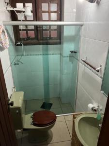 uma casa de banho com um chuveiro, um WC e um lavatório. em Aconchego Toque Toque em São Sebastião