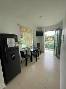 a living room with a table and a refrigerator at Cabañas Melany in Coveñas