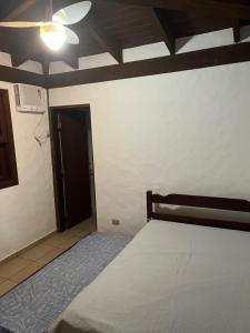 um quarto com uma cama e uma ventoinha de tecto em Aconchego Toque Toque em São Sebastião