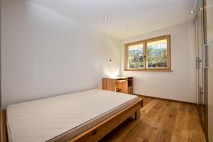 a bedroom with a large bed and a window at Landhaus Kirchberg in Kirchberg in Tirol