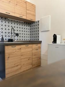 una cocina con armarios de madera y fregadero en Le Pietre Apartments, en Ostuni