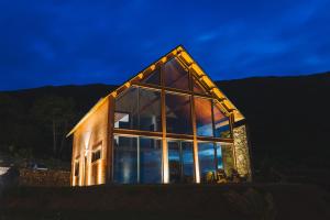 a house with large glass windows on the side of it at Cabanas do Pico 2A in Canto da Areia +5 photos