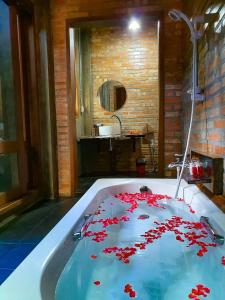 ein Badezimmer mit einer Badewanne mit roten Blumen. in der Unterkunft Kung Nok Tha Resort Nakhon Si Thammarat in Nakhon Si Thammarat