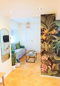 a living room with a couch and a painting on the wall at Exclusivo y luminoso Estudio c/Balcón in Buenos Aires