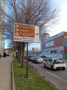 een straatbord aan de kant van een straat met auto's bij Q Flat Skyview Central Bradford in Bradford