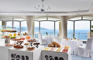 un tavolo con cibo sopra in una stanza con finestre di Hotel Raito Wellness & SPA a Vietri