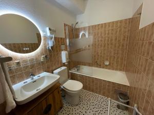 La salle de bains est pourvue d'un lavabo, de toilettes et d'un miroir. dans l'établissement Balzac Hôtel, à Fougères