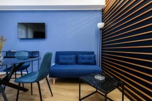 un soggiorno con divano blu e tavolo di APPARTAMENTI VALLETTI ERCOLANO a Ercolano