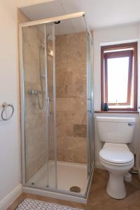 a bathroom with a shower and a toilet at Coastal Bungalow Near Marloes with Log Burner and Garden in Dale