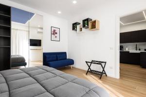 una camera con un grande letto e una sedia blu di APPARTAMENTI VALLETTI ERCOLANO a Ercolano