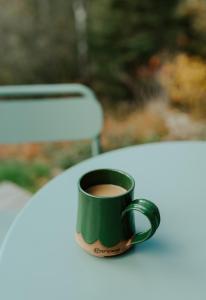a green coffee cup sitting on top of a table at Tofte Trails in Tofte