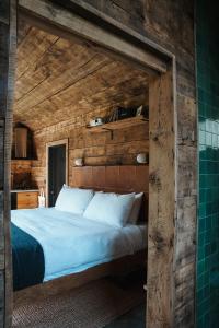 a bed in a room with a wooden wall at Tofte Trails in Tofte