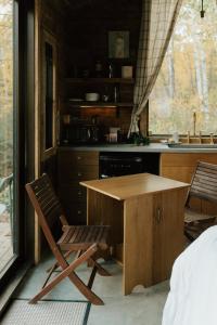 une cuisine avec une table en bois et deux chaises dans l'établissement Tofte Trails, à Tofte