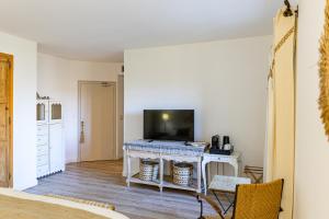a living room with a tv and a table with a television at Maison Bournissac in Noves