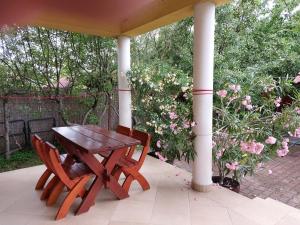 a wooden table and two chairs on a porch at Hanol Apartmanház Balatonlelle in Balatonlelle