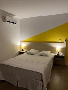 a bedroom with a large bed with two pillows at Mova Express Hotel - CAMPINAS in Campinas