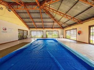 uma grande piscina num edifício com um tecto grande em Apartamento 4 Dorm e Piscina by Achei Gramado em Gramado