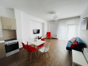 Una cocina y una sala de estar con mesa y sillas. en ApartHotel Villa Eva 2 bedroom, en Olympiakí Aktí