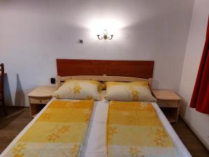 a bedroom with two beds with yellow and white blankets at Hanol Apartmanház Balatonlelle in Balatonlelle