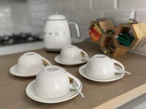 trois tasses à thé et soucoupes sur une table dans l'établissement StaySure Guesthouse, à Alberton
