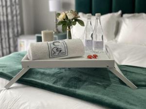 - un plateau avec des serviettes et des bouteilles sur un lit dans l'établissement StaySure Guesthouse, à Alberton