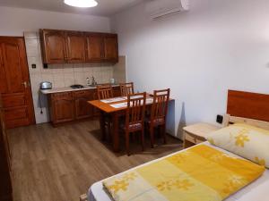 a room with a kitchen and a table and a bed at Hanol Apartmanház Balatonlelle in Balatonlelle +94 photos