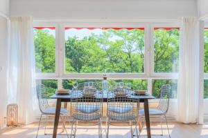 a dining room with a table and chairs and a large window at Spacious 3 bedroom apartment & private parking! in Lambersart