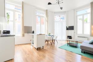 ein Wohnzimmer mit Sofa und Tisch in der Unterkunft Functional flat close to the station in Lille