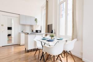 eine Küche und ein Esszimmer mit Tisch und Stühlen in der Unterkunft Functional flat close to the station in Lille
