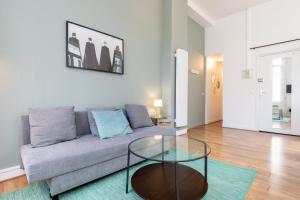 ein Wohnzimmer mit einer Couch und einem Glastisch in der Unterkunft Functional flat close to the station in Lille