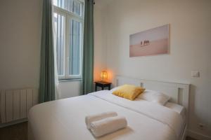 1 dormitorio con cama blanca y ventana en 2-bedroom flat + private car park., en Lille