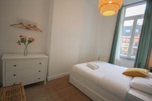 a bedroom with a bed and a dresser and a window at 2-bedroom flat + private car park. in Lille