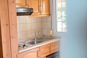 a kitchen with a sink and a window at Guesthouse Agnandi in Kato Loutraki