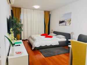 a bedroom with a bed with red pillows on it at Nova Galerija Studio App Bella,Lara,Katy in Zagreb