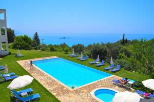 una gran piscina con sillas y sombrillas en Apartments and studio with swimming pool and Sea View in Pelekas Beach, Corfu, en Pelekas
