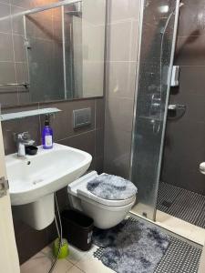 ein Bad mit einer Dusche, einem WC und einem Waschbecken in der Unterkunft Cozy Skyline View Unit at Acqua @Livingstone in Manila