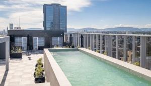a swimming pool on the roof of a building at Nido Nomad Las Américas GDL in Guadalajara