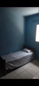 Casa Relax في كاراغواتاتوبا: سرير في غرفة زرقاء مع نافذة