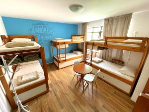 a room with four bunk beds and a table and chair at Jardim Botânico House in Curitiba