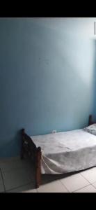 Ce lit se trouve dans un dortoir doté d'un mur bleu. dans l'établissement Casa Relax, à Caraguatatuba