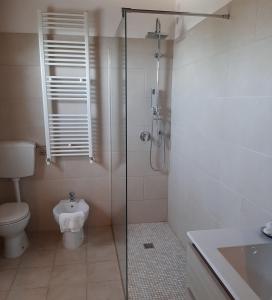 ein Bad mit einem WC und einer Glasdusche in der Unterkunft Tenuta di Forte Sorgnano in Gualdo Cattaneo