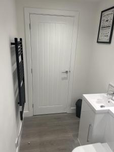 a bathroom with a white door and a sink at Lovely 1-Bed Apartment in Glastonbury in Glastonbury