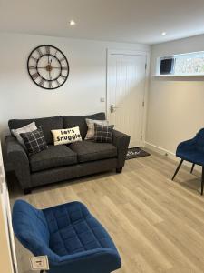 a living room with a couch and a clock on the wall at Lovely 1-Bed Apartment in Glastonbury in Glastonbury